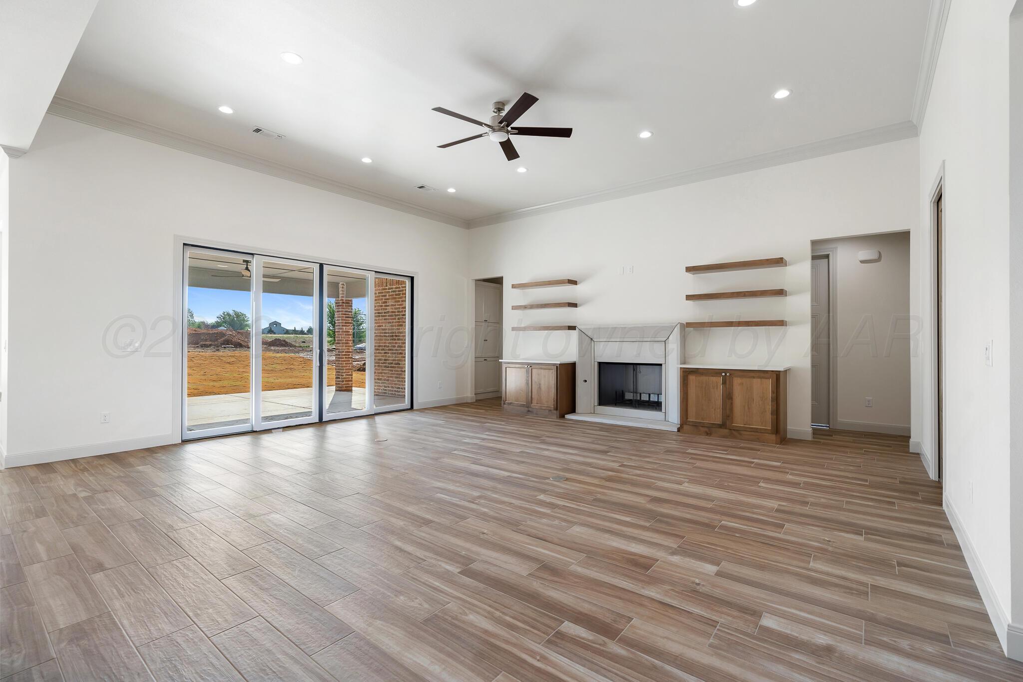 16551 Spring Lake Drive Canyon, TX 79015 - Photo 26 of 60 a view of a room with wooden floor and a ceiling fan