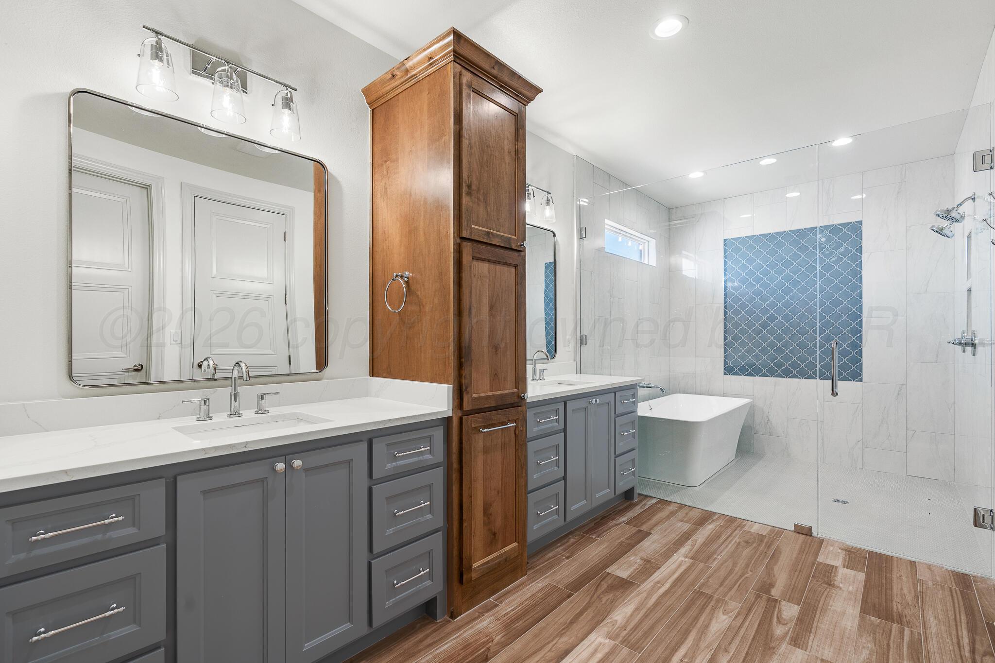 16551 Spring Lake Drive Canyon, TX 79015 - Photo 32 of 60 a spacious bathroom with a double vanity sink a large mirror and a bathtub
