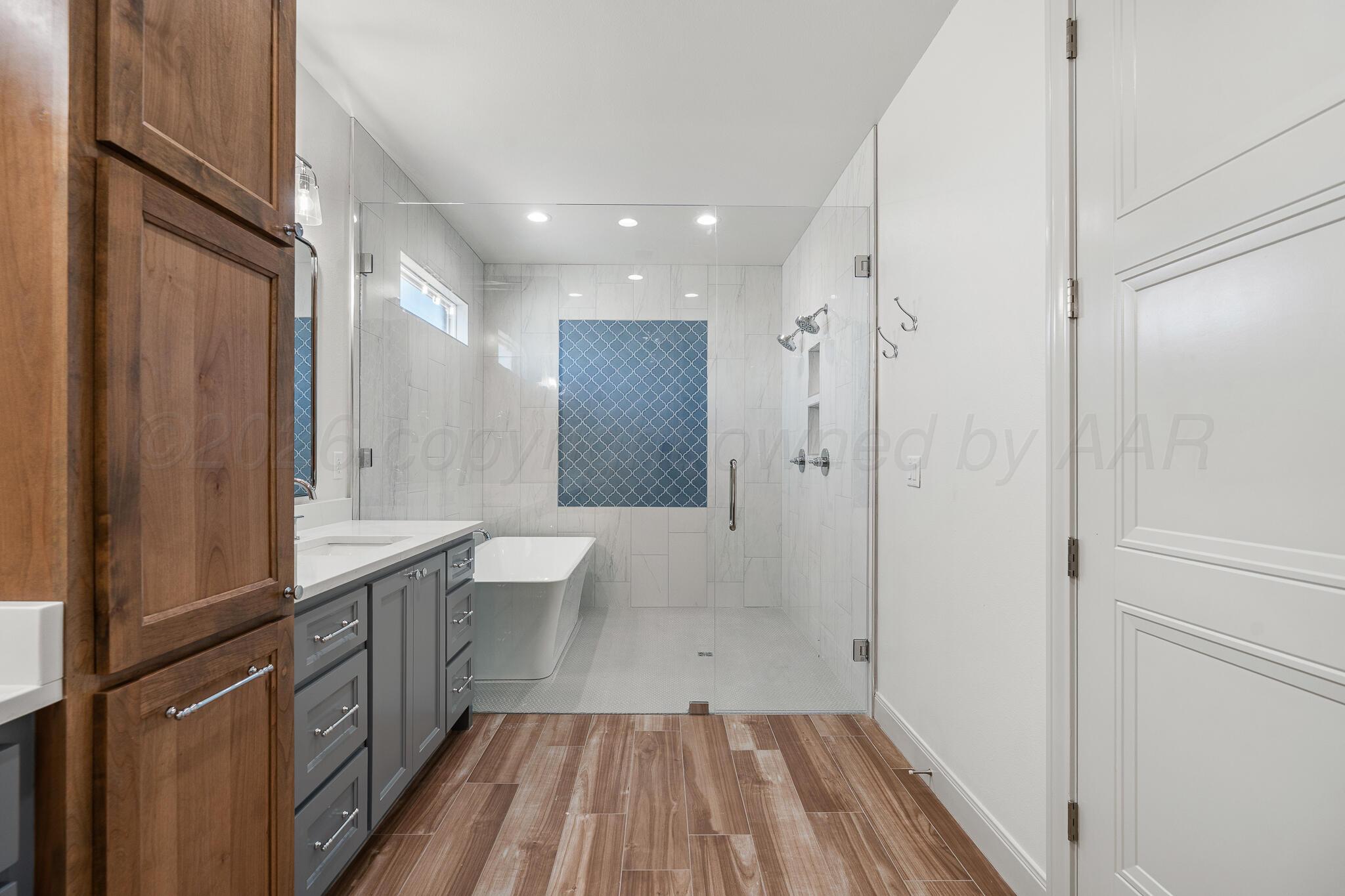 16551 Spring Lake Drive Canyon, TX 79015 - Photo 35 of 60 a bathroom with a sink a toilet a large mirror and shower