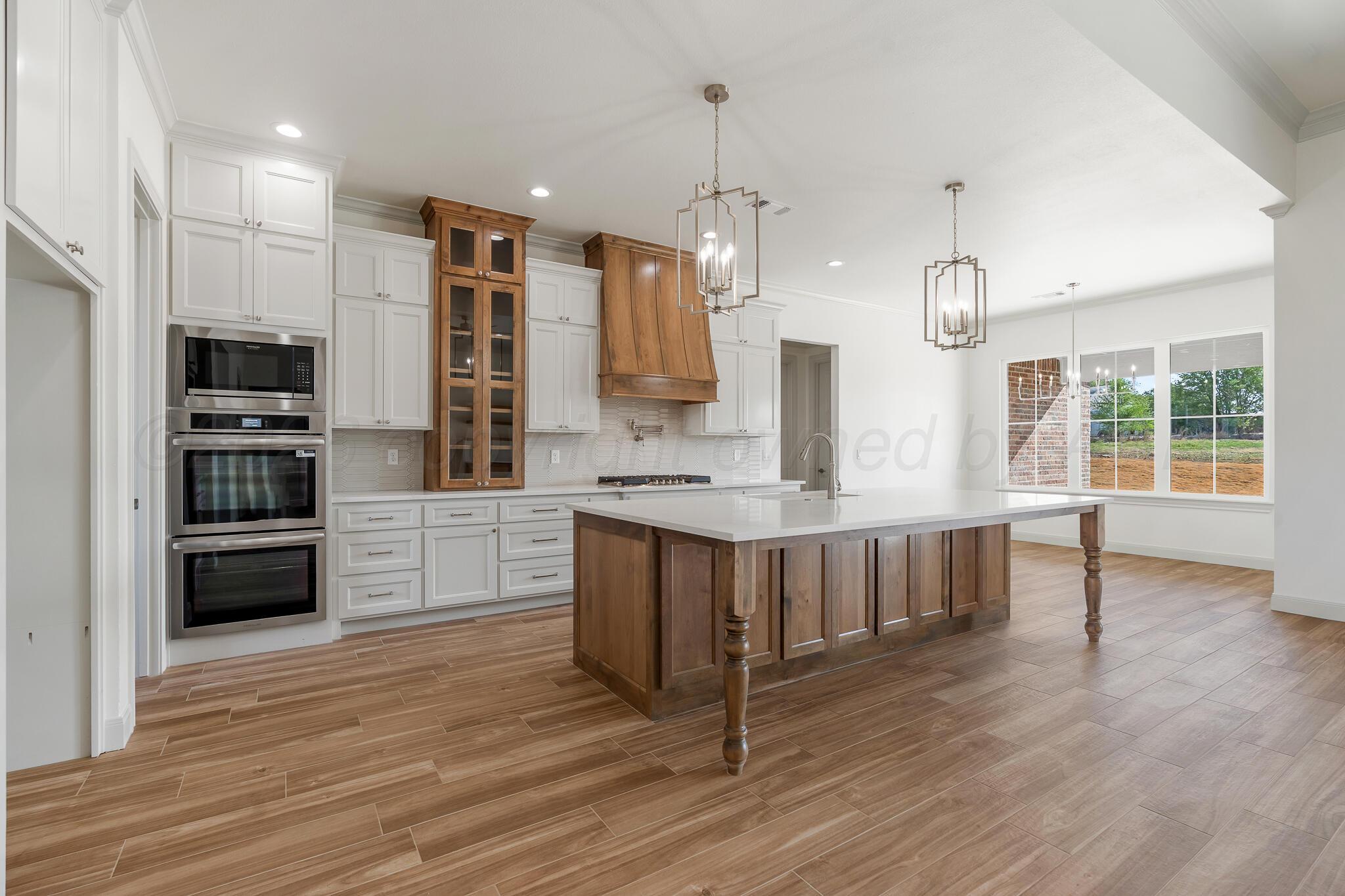 16551 Spring Lake Drive Canyon, TX 79015 - Photo 7 of 60 a kitchen with stainless steel appliances kitchen island granite countertop a stove a refrigerator and a wooden floors