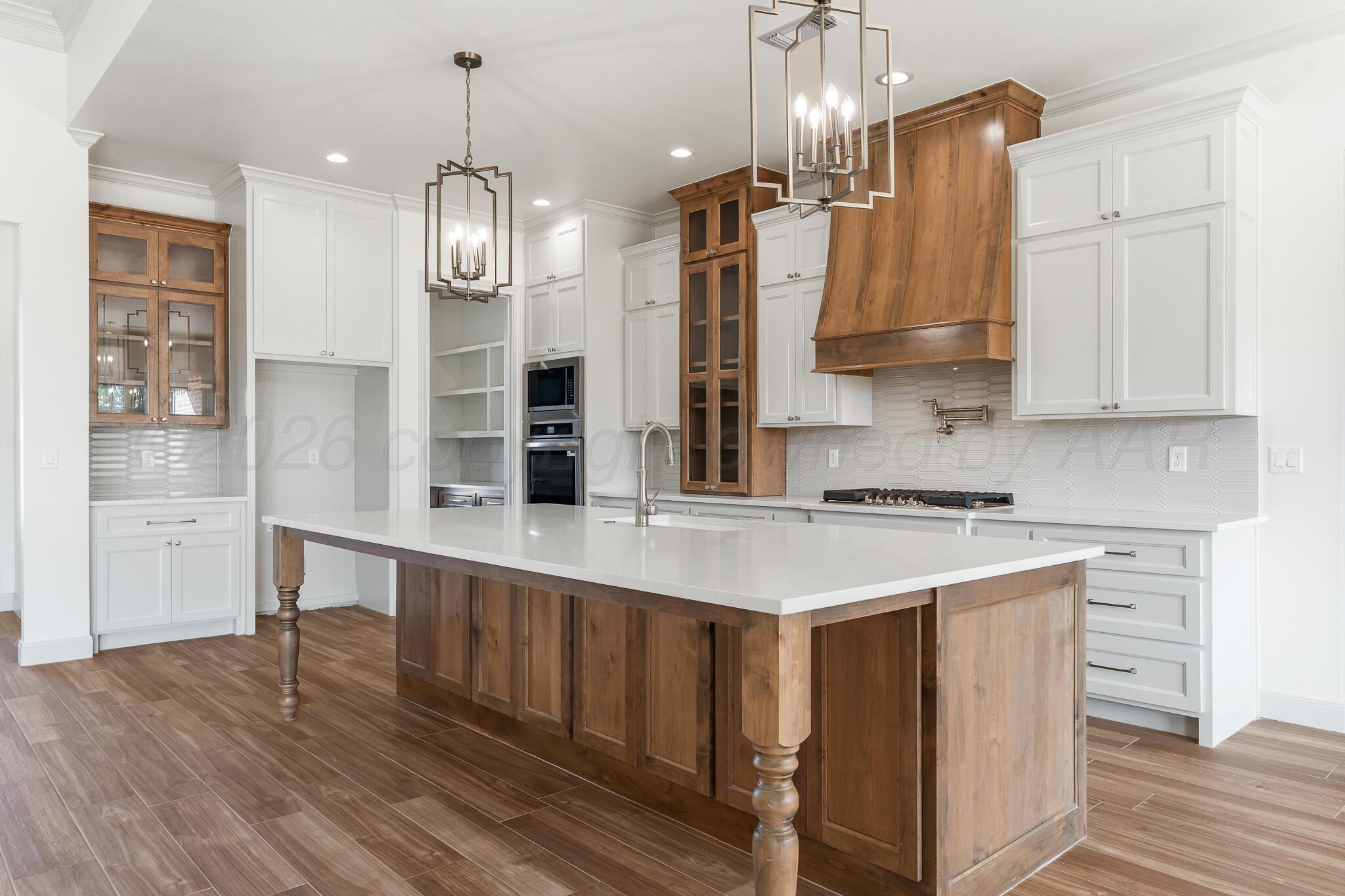 16551 Spring Lake Drive Canyon, TX 79015 - Photo 8 of 60 a kitchen that has a lot of cabinets in it and wooden floors