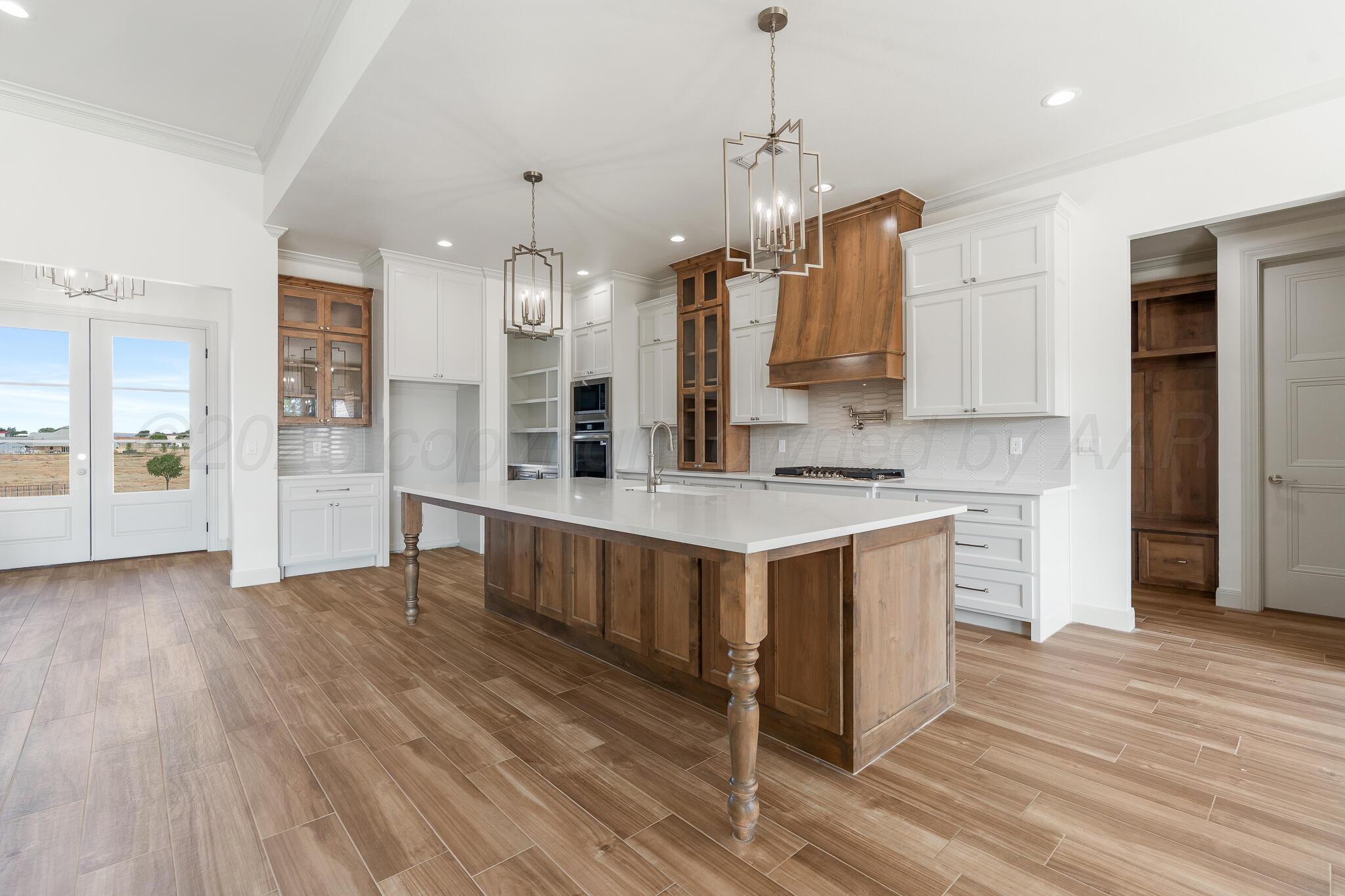 16551 Spring Lake Drive Canyon, TX 79015 - Photo 9 of 60 a large kitchen with stainless steel appliances granite countertop a sink a counter space and wooden floor