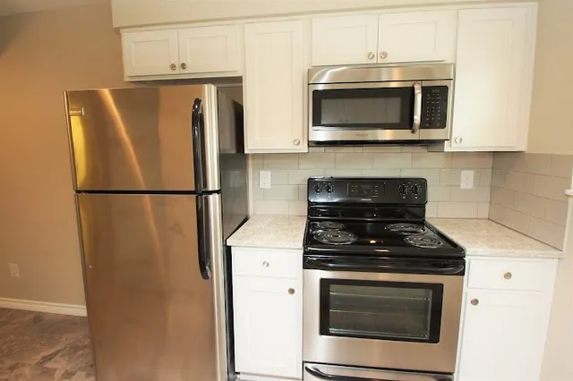 a kitchen with stainless steel appliances a stove microwave and a refrigerator