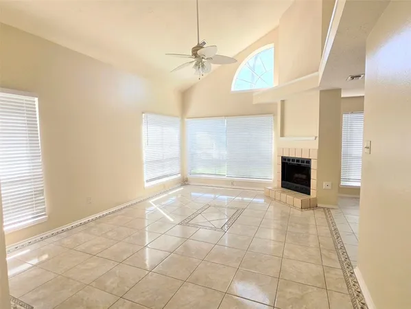 a view of an empty room with a fireplace and a window