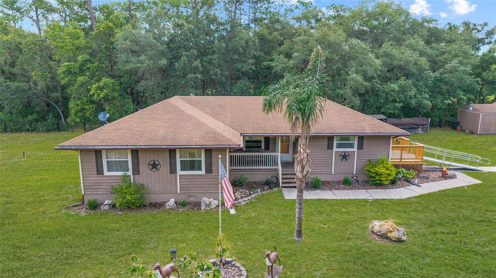 15755 Southwest 90th Avenue Dunnellon, FL 34432 - Photo 2 of 55 a aerial view of a house next to a big yard and large trees