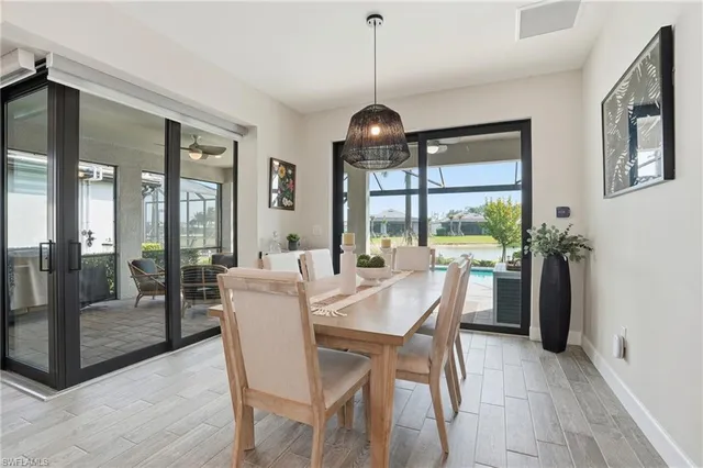 a dining room with furniture a chandelier and wooden floor