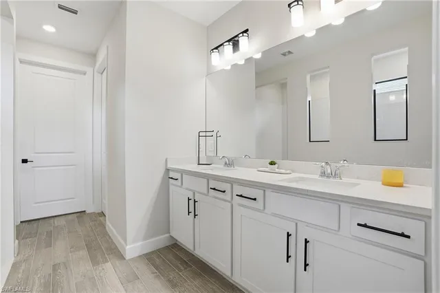 a bathroom with a double vanity sink and mirror