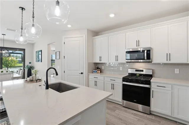 a kitchen with granite countertop white cabinets and stainless steel appliances