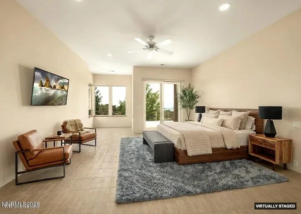 a spacious bedroom with a bed a couch and large window