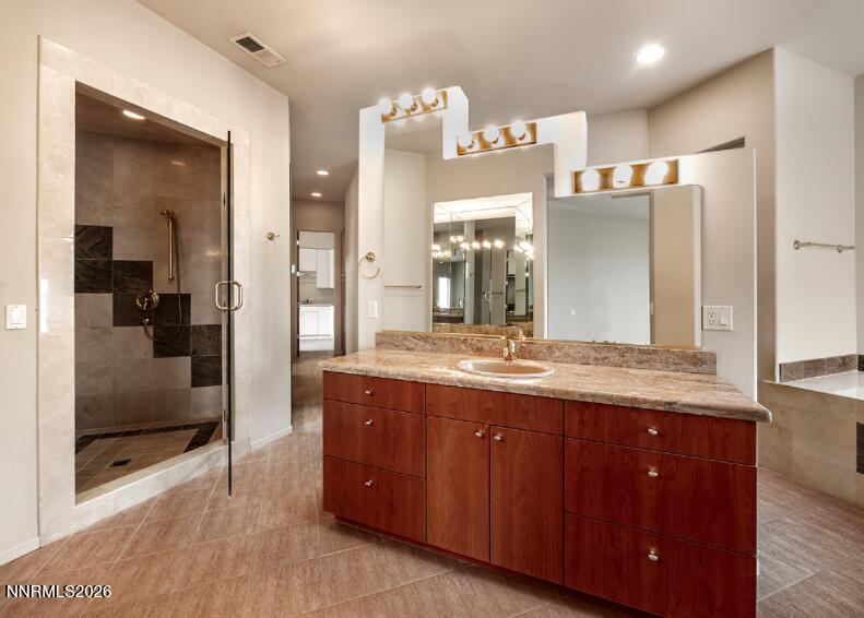 10123 Indian Ridge Drive Reno, NV 89511 - Photo 14 of 33 a bathroom with a granite countertop sink a large mirror and a shower
