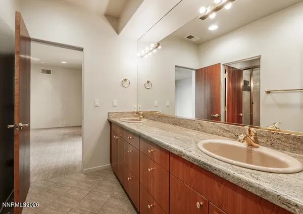 a bathroom with a granite countertop sink and a mirror