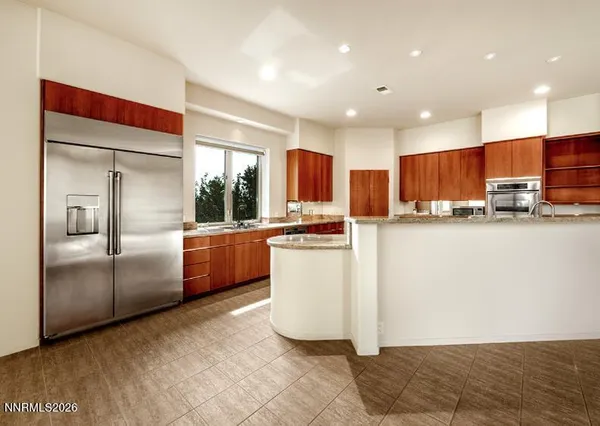 a kitchen with granite countertop a refrigerator and a sink
