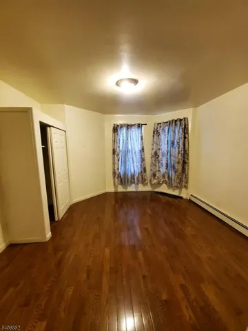 a view of room with wooden floor and windows