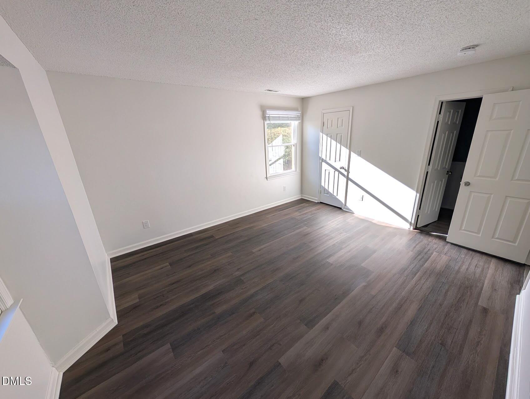 2020 Quaker Landing, Unit 103 Raleigh, NC 27603 - Photo 15 of 19 a view of an empty room with wooden floor and a window