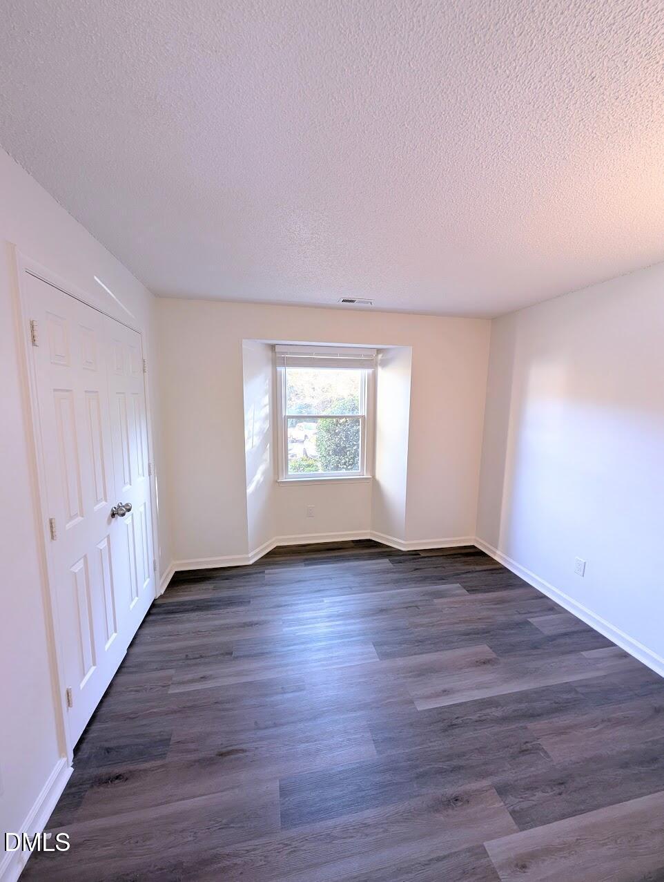2020 Quaker Landing, Unit 103 Raleigh, NC 27603 - Photo 9 of 19 a view of an empty room with wooden floor and window