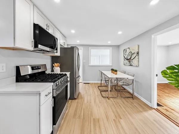 a kitchen with stainless steel appliances kitchen island granite countertop a stove top oven a sink a dining table and chairs