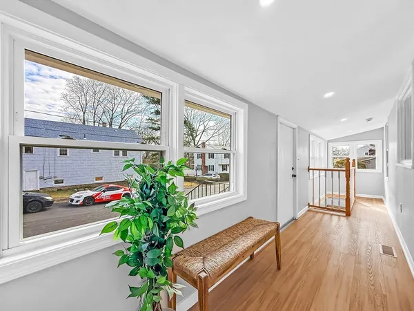a view of a hallway with wooden floor and dining room