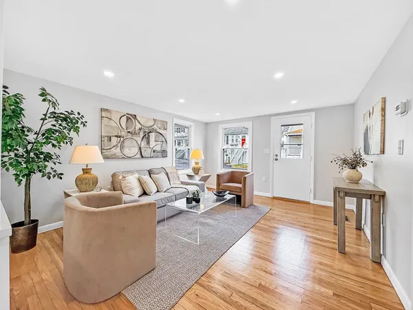 a living room with furniture and wooden floor