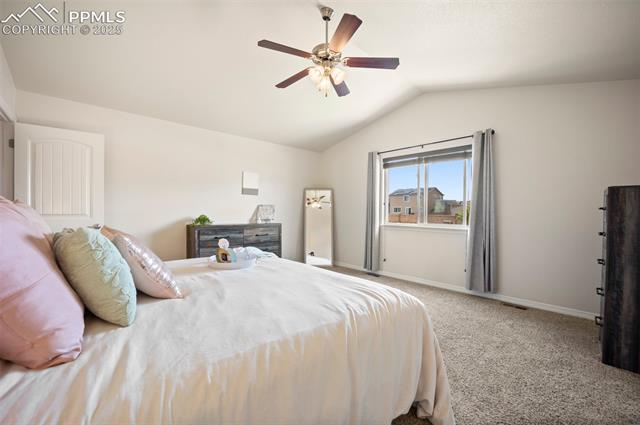 7148 Red Cardinal Loop Colorado Springs, CO 80908 - Photo 28 of 50 Carpeted bedroom featuring lofted ceiling, baseboards, and a ceiling fan