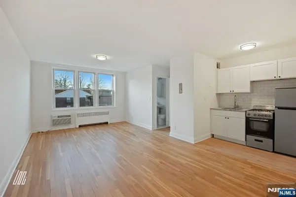 a view of a kitchen with a sink stove cabinets and empty room