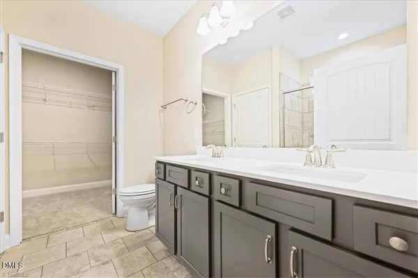 a bathroom with a sink a toilet and a large mirror