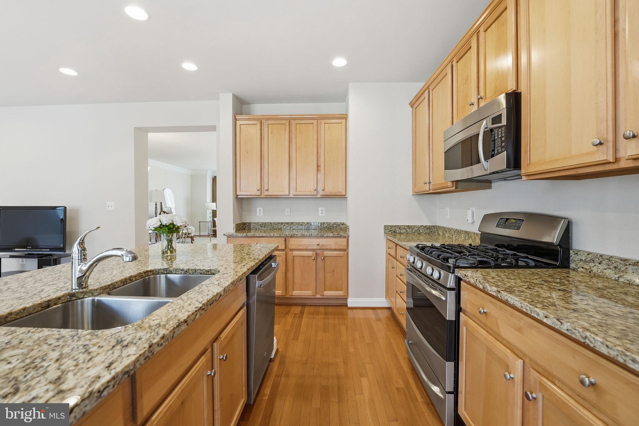 8015 Reserve Way Vienna, VA 22182 - Photo 19 of 58 a kitchen with stainless steel appliances granite countertop a sink stove and refrigerator