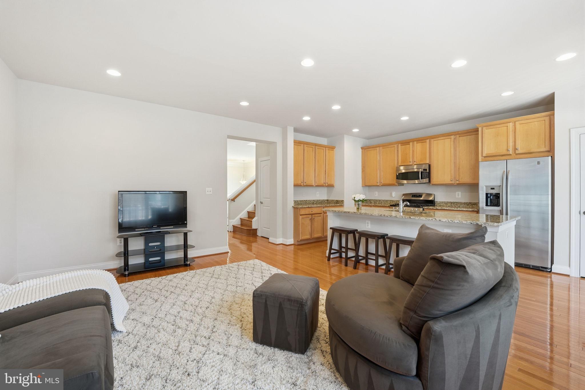 8015 Reserve Way Vienna, VA 22182 - Photo 22 of 58 a living room with furniture and a flat screen tv with kitchen view