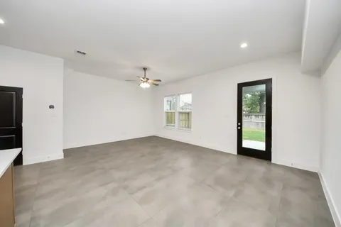 an empty room with wooden floor and a ceiling fan