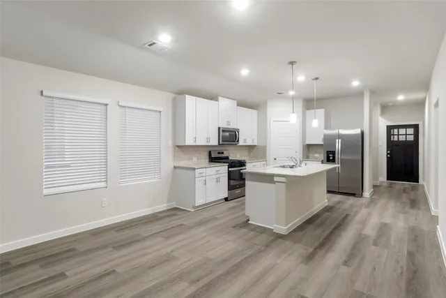 a large kitchen with a lot of counter space and stainless steel appliances