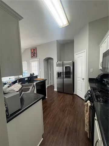 a kitchen with stainless steel appliances a refrigerator a stove a sink and a refrigerator