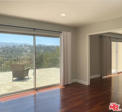 a view of a room with wooden floor and a window