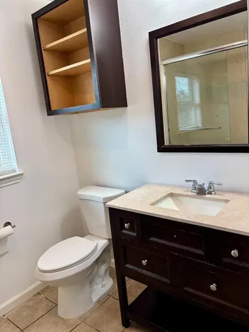 a bathroom with a toilet sink vanity and mirror