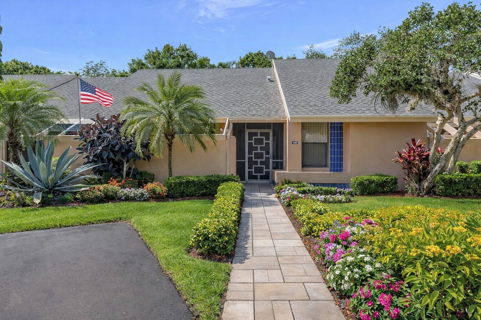 a front view of a house with a yard and potted plants