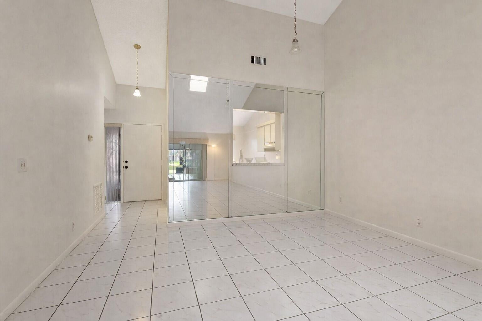 10884 Waterberry Court Boca Raton, FL 33498 - Photo 11 of 39 an empty room with white walls and natural light