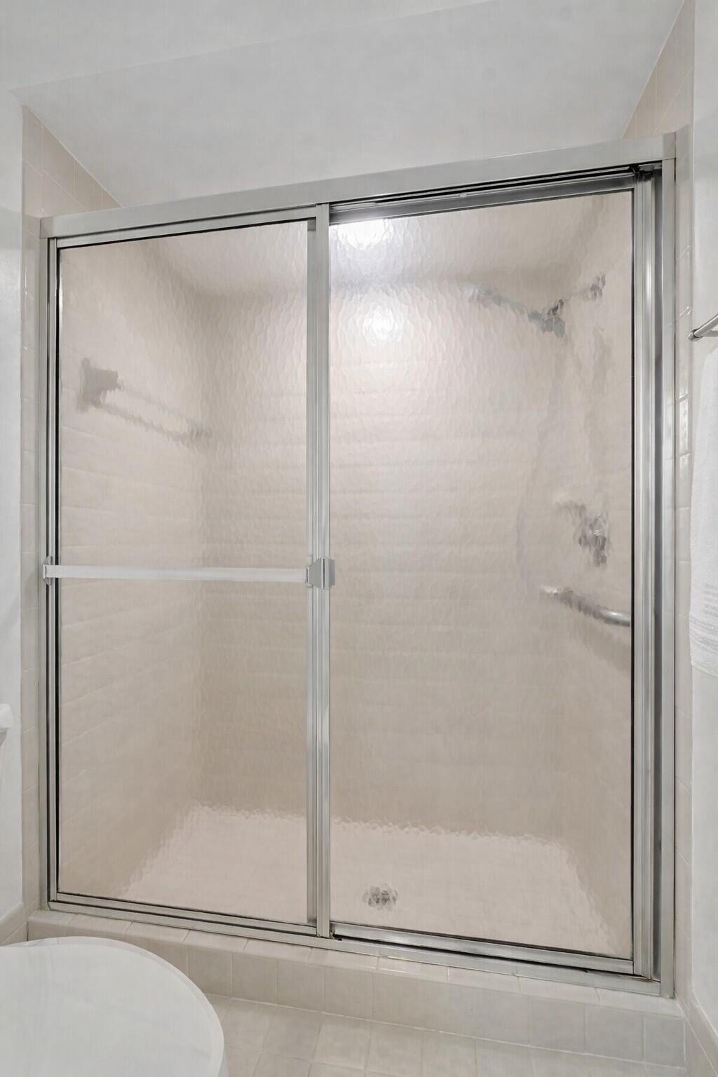 10884 Waterberry Court Boca Raton, FL 33498 - Photo 24 of 39 a bathroom with a glass shower door