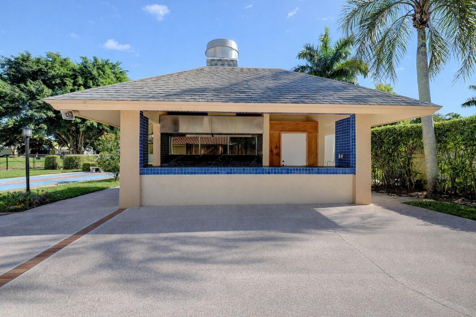 10884 Waterberry Court Boca Raton, FL 33498 - Photo 39 of 39 a front view of a house with a yard and potted plants