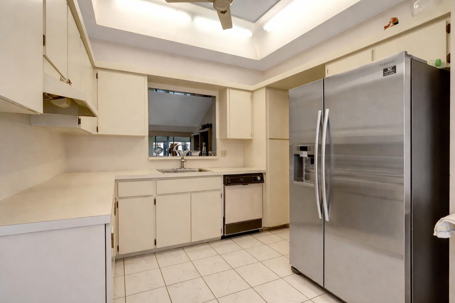 10884 Waterberry Court Boca Raton, FL 33498 - Photo 8 of 39 a kitchen with a refrigerator sink and white cabinets