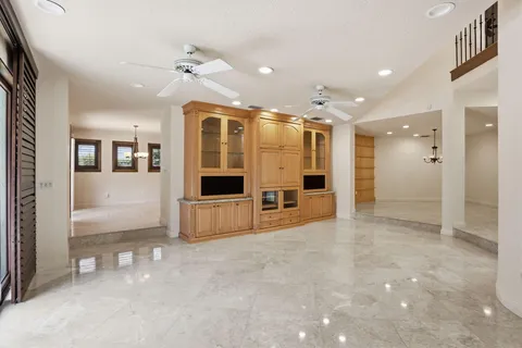 a view of empty room with wooden floor and ceiling fan