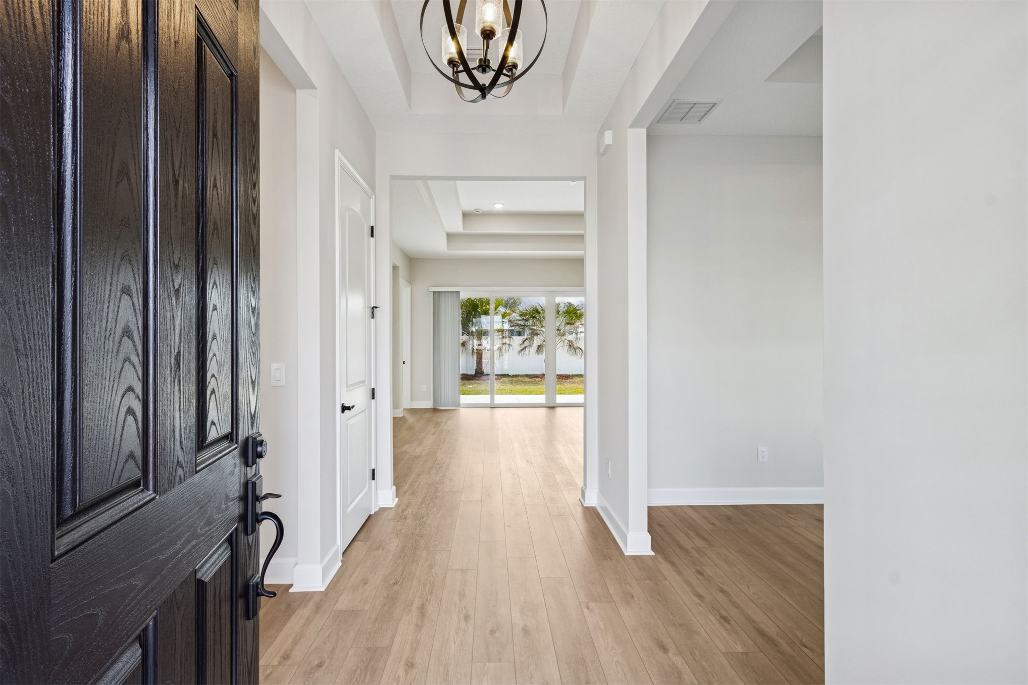 85228 Sandy Rdg Loop Yulee, FL 32097 - Photo 4 of 24 a view of a hallway with wooden floor and a chandelier