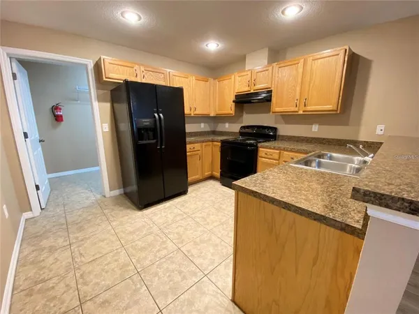 a kitchen with stainless steel appliances granite countertop a refrigerator a stove and a sink