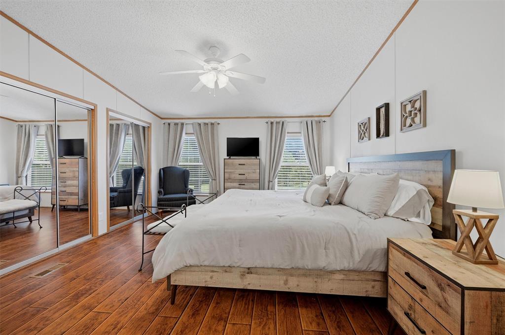 212 Sunset Road Pottsboro, TX 75076 - Photo 14 of 40 a bedroom with a bed and wooden floor