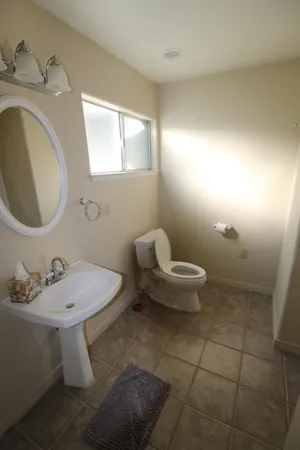 a bathroom with a sink toilet and a mirror