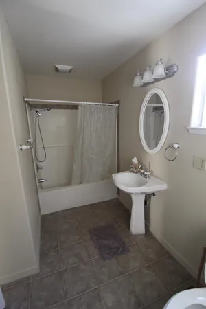 a bathroom with a sink toilet and a mirror