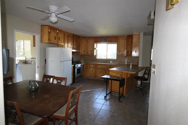 a kitchen with a refrigerator a table and chairs in it