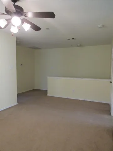 en empty room with a ceiling fan and a window