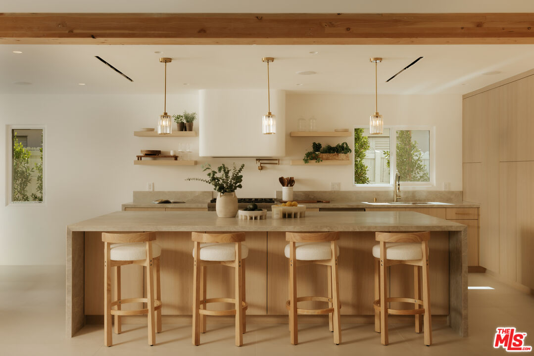 880 Teakwood Road Los Angeles, CA 90049 - Photo 12 of 38 a kitchen with cabinets and chairs