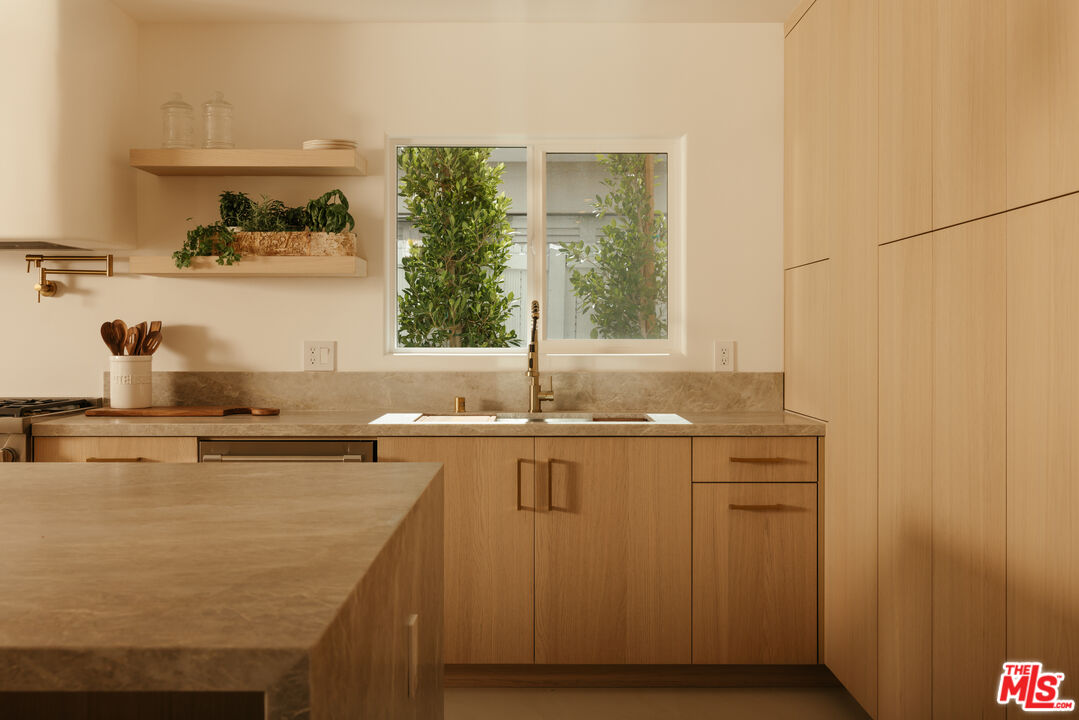 880 Teakwood Road Los Angeles, CA 90049 - Photo 13 of 38 a kitchen with sink cabinets and window