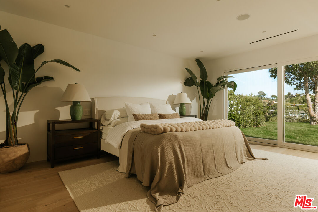 880 Teakwood Road Los Angeles, CA 90049 - Photo 15 of 38 a bedroom with a bed and a painting on the wall