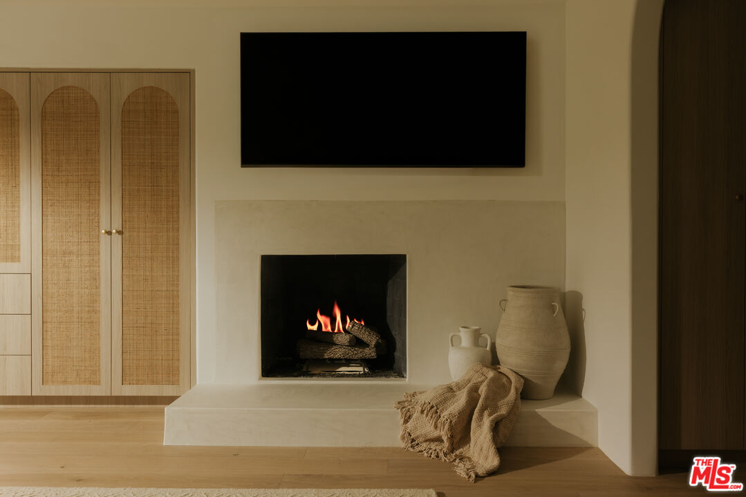 880 Teakwood Road Los Angeles, CA 90049 - Photo 16 of 38 a living room with a fireplace and a flat screen tv
