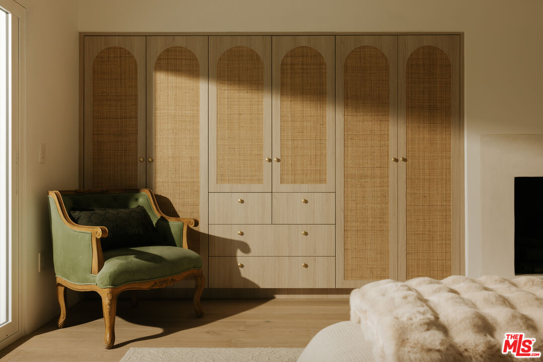 880 Teakwood Road Los Angeles, CA 90049 - Photo 17 of 38 a bedroom with a bed and wooden floor
